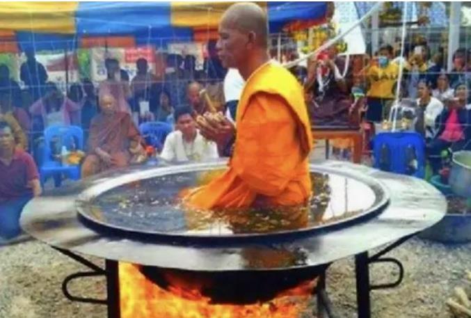 泰国高僧坐在翻滚的油锅里表演，淡定自若，却被观众当场拆穿